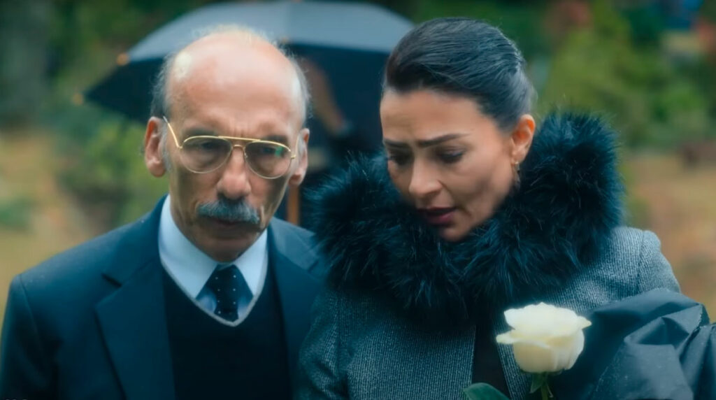 Escena del tráiler de 'Betty La Fea: La historia continúa' mostrando a Betty (Ana María Orozco) con su padre (Jorge Herrera) en el funeral de Roberto Mendoza