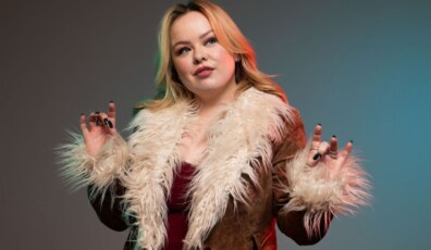 Nicola Coughlan posando con una chaqueta de piel sintética, mostrando una actitud confiada y estilosa